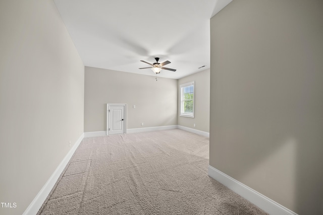 unfurnished room featuring a ceiling fan, baseboards, and light colored carpet