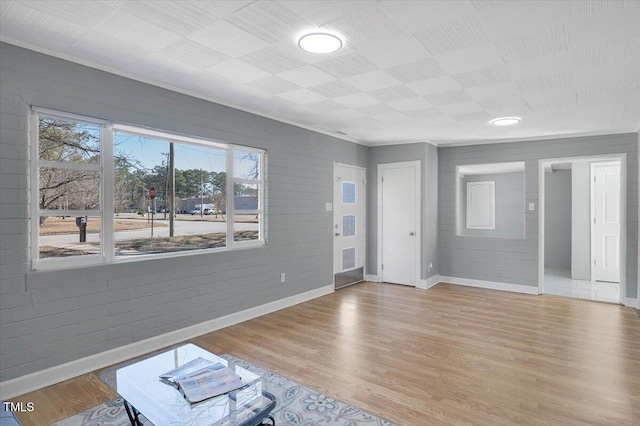 foyer entrance featuring light hardwood / wood-style flooring and brick wall