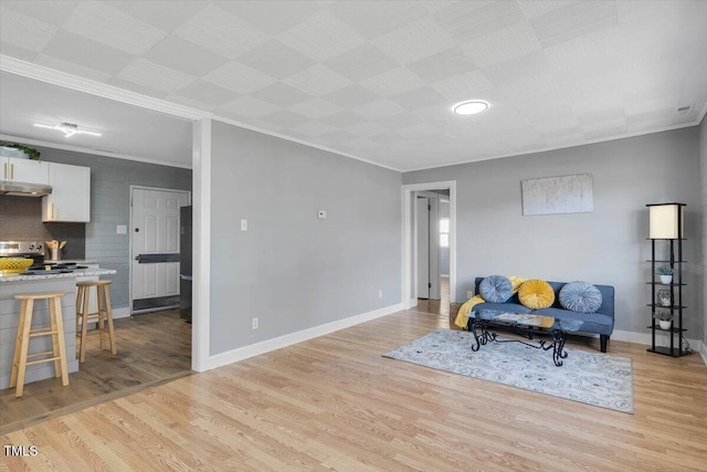 sitting room with ornamental molding and light hardwood / wood-style floors