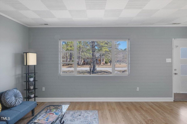 unfurnished living room featuring crown molding and light hardwood / wood-style floors