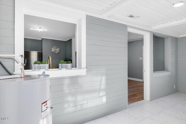 interior space with water heater and crown molding