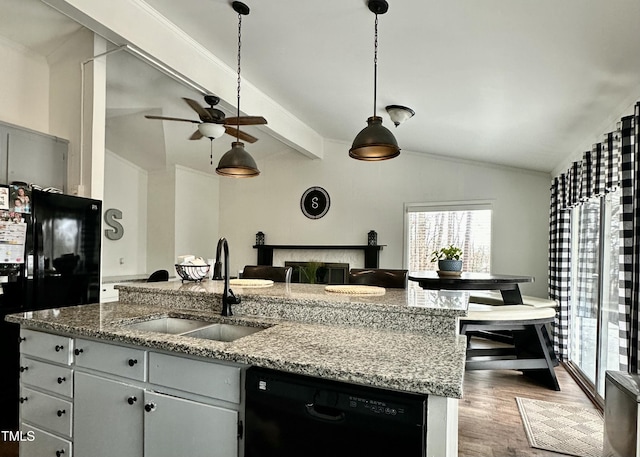 kitchen featuring sink, light stone counters, lofted ceiling with beams, dark hardwood / wood-style floors, and black appliances