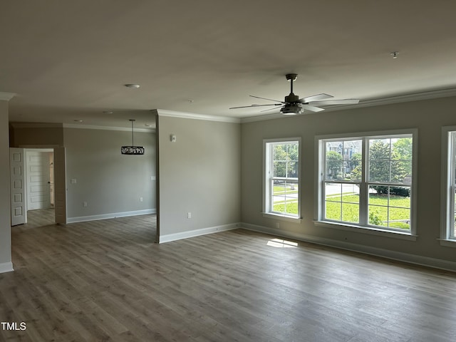 spare room featuring crown molding, baseboards, a ceiling fan, and wood finished floors