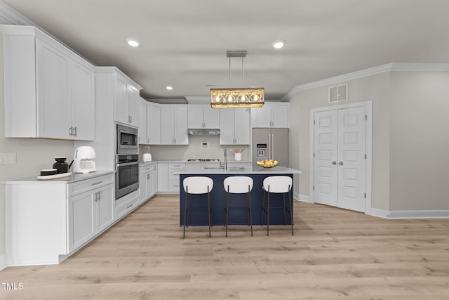 1400 Gathering Park Cir Unit 202, Cary, NC 27519 - kitchen with appliances with stainless steel finishes, crown molding, white cabinets, a breakfast bar, and under cabinet range hood