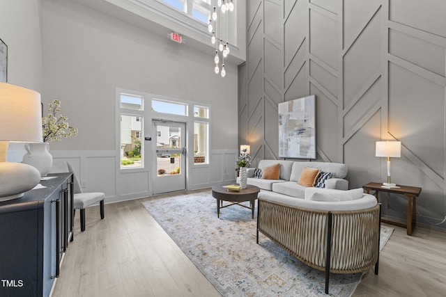 1400 Gathering Park Cir Unit 202, Cary, NC 27519 - living area with a decorative wall, a towering ceiling, light wood finished floors, and wainscoting