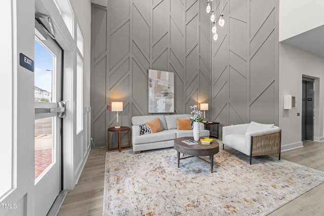 1400 Gathering Park Cir Unit 202, Cary, NC 27519 - living room featuring a decorative wall, a towering ceiling, light wood finished floors, and elevator