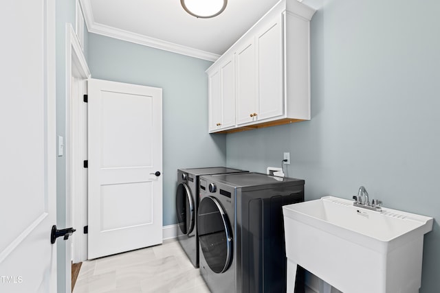 laundry area with cabinet space, baseboards, washing machine and clothes dryer, crown molding, and a sink