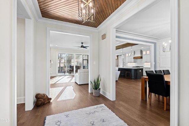 foyer entrance with wood ceiling, baseboards, ornamental molding, and dark wood-type flooring