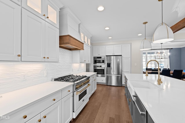 kitchen featuring appliances with stainless steel finishes, light countertops, ornamental molding, and white cabinetry