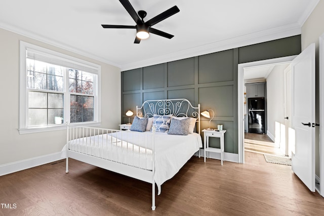 bedroom featuring a decorative wall, crown molding, and wood finished floors