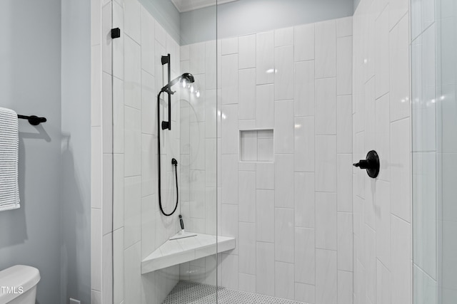 full bathroom featuring tiled shower and toilet