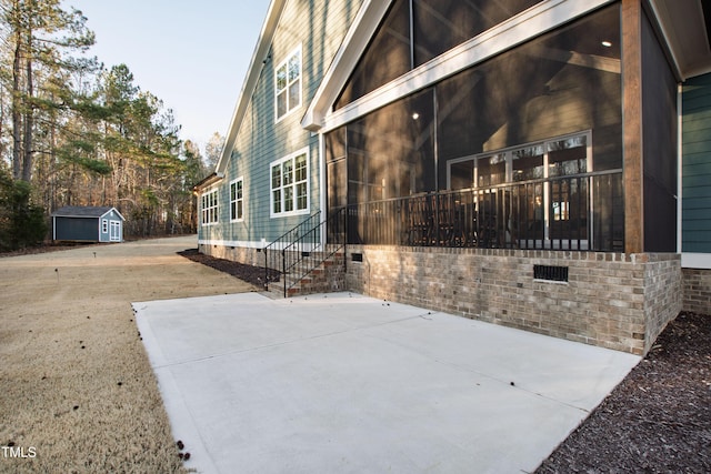 view of home's exterior featuring a patio, a sunroom, crawl space, an outdoor structure, and a shed