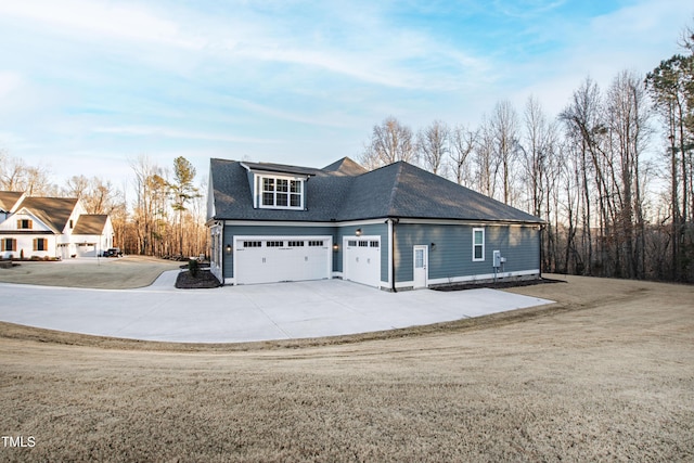 view of front facade featuring a shingled roof, a front yard, and concrete driveway