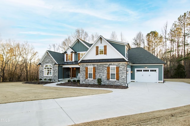 craftsman-style home featuring driveway, a standing seam roof, an attached garage, and a front lawn