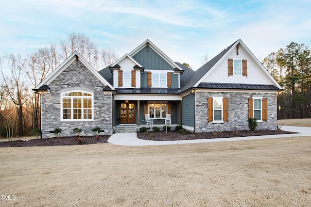 craftsman inspired home with metal roof, a porch, board and batten siding, a standing seam roof, and a front yard