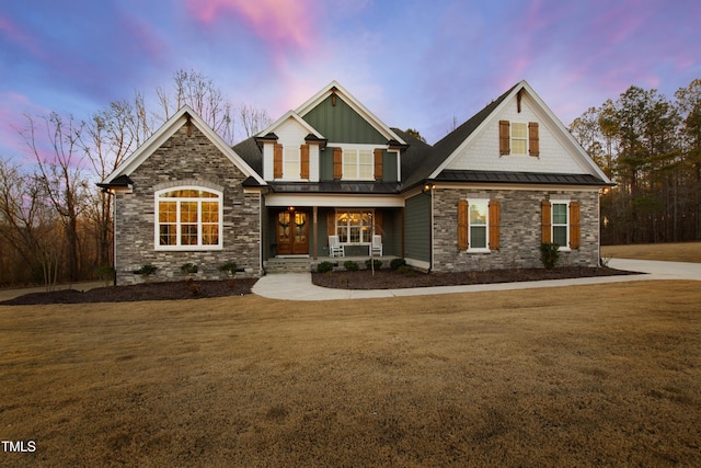 craftsman-style home with a standing seam roof, a porch, metal roof, and a front yard