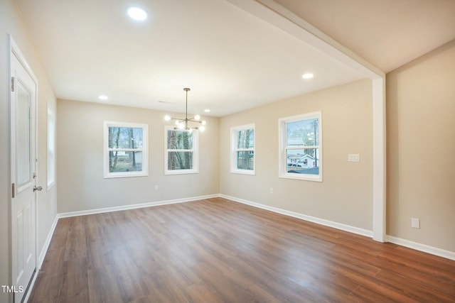 spare room with a notable chandelier, recessed lighting, baseboards, and dark wood-style flooring