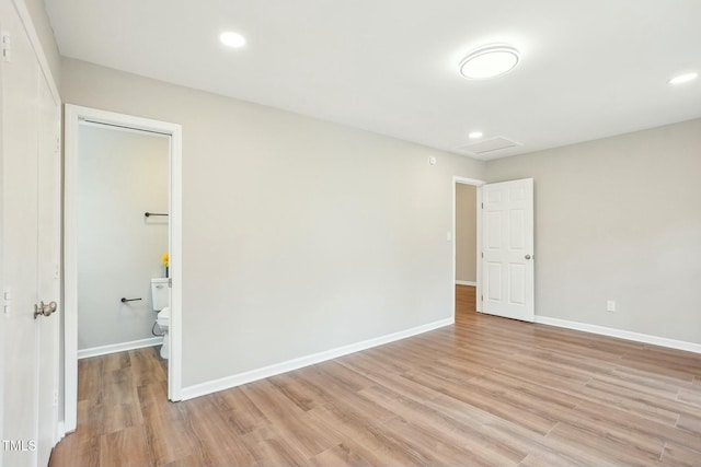 empty room featuring baseboards, recessed lighting, attic access, and light wood-style floors