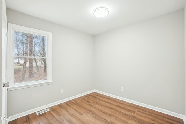 unfurnished room featuring baseboards, visible vents, and light wood-type flooring