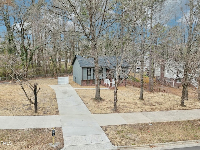 view of front facade with concrete driveway and fence