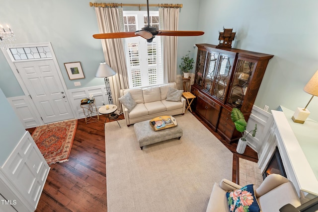 living room with dark hardwood / wood-style flooring and ceiling fan