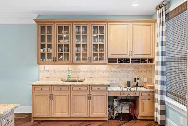 bar featuring crown molding, dark hardwood / wood-style floors, light stone countertops, and backsplash