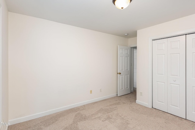 unfurnished bedroom with a closet and light carpet