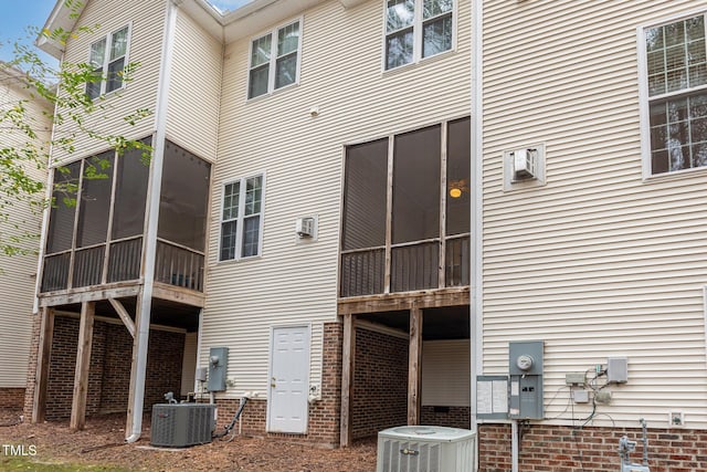 rear view of house featuring a sunroom and central air condition unit