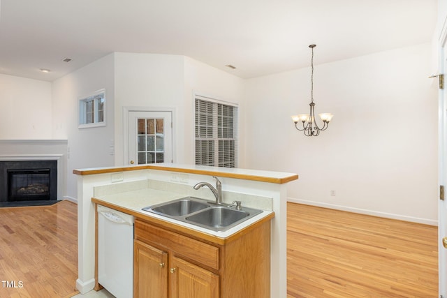 kitchen with sink, decorative light fixtures, a chandelier, light hardwood / wood-style flooring, and dishwasher