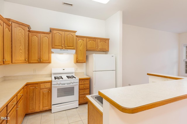 kitchen featuring light tile patterned flooring and white appliances