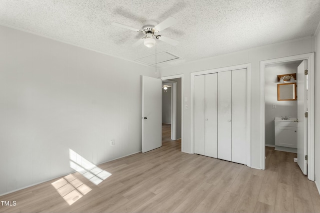 unfurnished bedroom with a textured ceiling, a closet, ceiling fan, and light hardwood / wood-style flooring