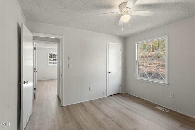 unfurnished bedroom featuring light wood-type flooring and a textured ceiling