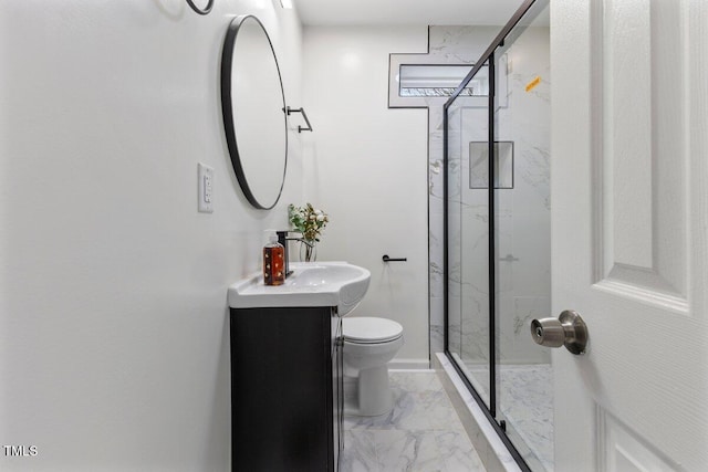 bathroom with a shower with door, vanity, and toilet