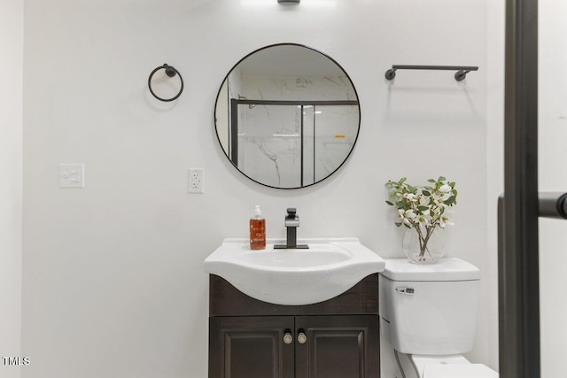 bathroom featuring vanity, toilet, and a shower