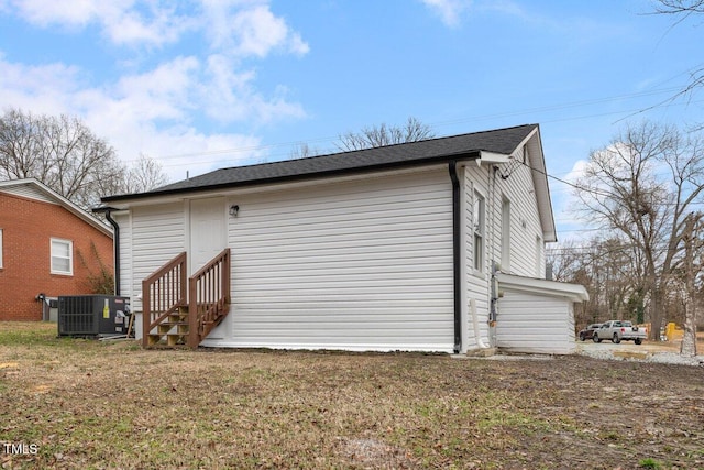 view of side of home with a lawn and central air condition unit