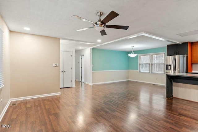 unfurnished living room featuring dark wood-type flooring and ceiling fan