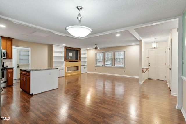 kitchen with hanging light fixtures, a kitchen island, hardwood / wood-style flooring, and a textured ceiling