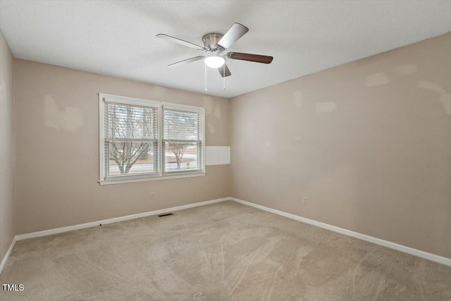 carpeted spare room featuring a textured ceiling and ceiling fan