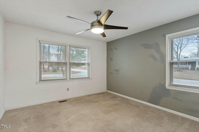 unfurnished room with light colored carpet and ceiling fan