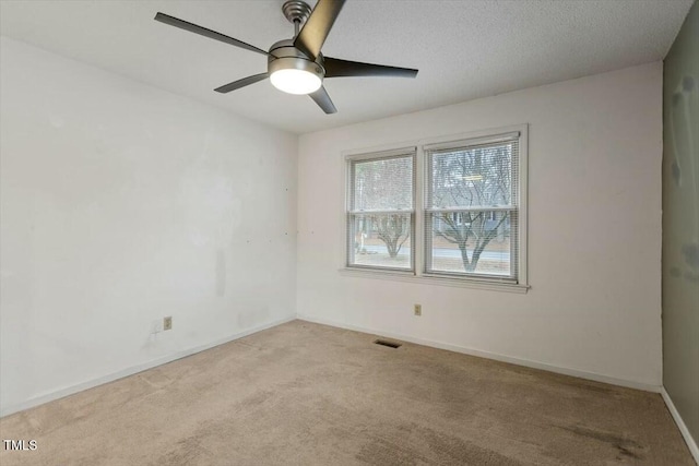 carpeted spare room with ceiling fan and a textured ceiling