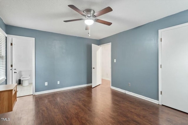 unfurnished bedroom featuring dark hardwood / wood-style flooring, ceiling fan, and ensuite bathroom