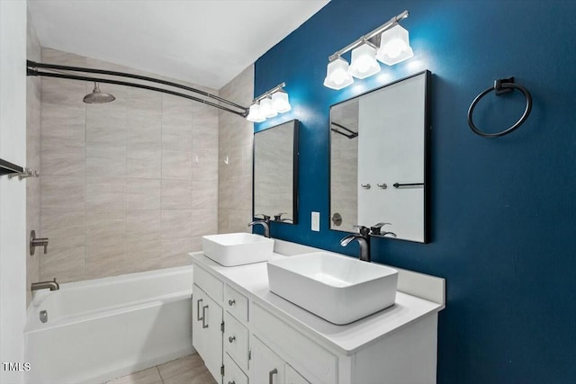 bathroom with tiled shower / bath combo, vanity, and tile patterned flooring