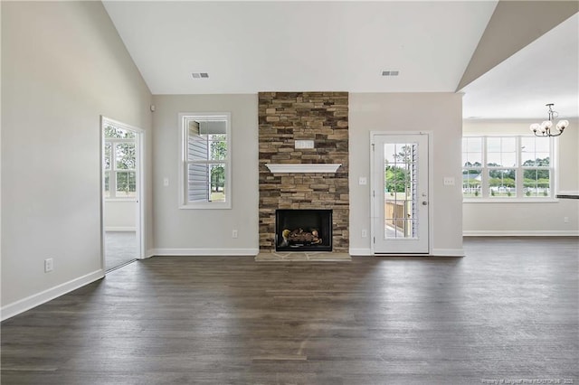 unfurnished living room with an inviting chandelier, a healthy amount of sunlight, vaulted ceiling, and visible vents