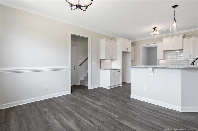 kitchen with crown molding, tasteful backsplash, and white cabinetry