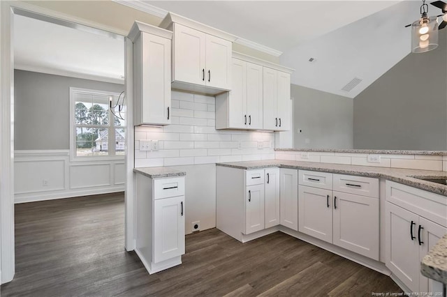 kitchen with light stone countertops, white cabinetry, and dark wood-type flooring