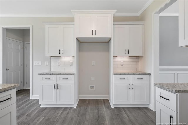 kitchen with light stone counters, white cabinetry, wood finished floors, and tasteful backsplash