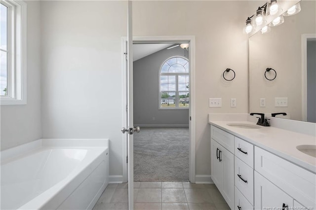 full bath featuring a sink, tile patterned flooring, double vanity, baseboards, and a garden tub