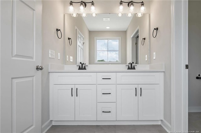 full bath featuring double vanity, baseboards, visible vents, and a sink