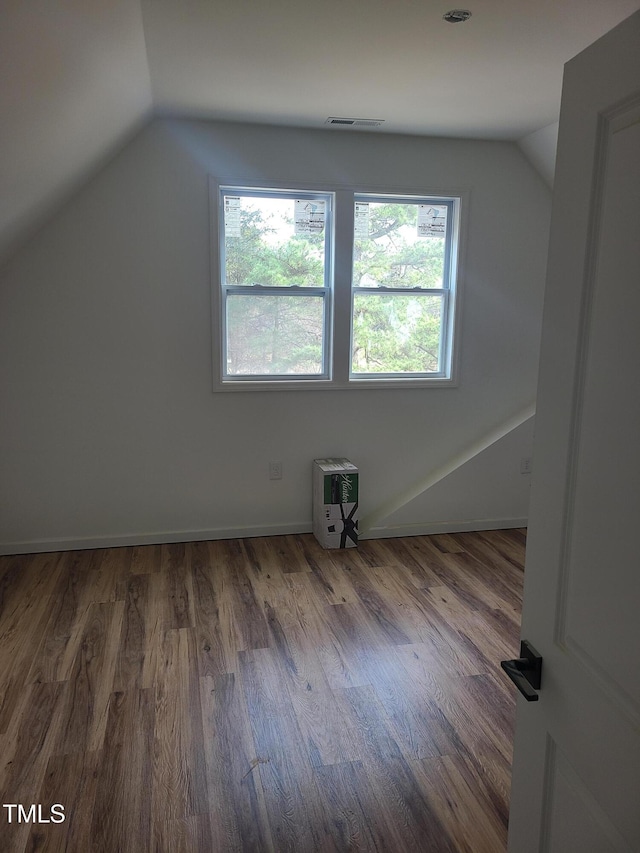 additional living space featuring lofted ceiling and hardwood / wood-style floors