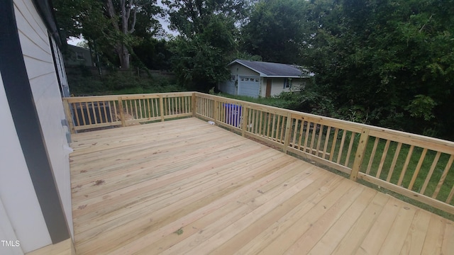 wooden deck featuring a garage and an outdoor structure